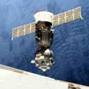 손상된 승무원 캡슐을 교체하기 위해 우주 정거장에 무인 소유즈 우주선 도킹 이미지